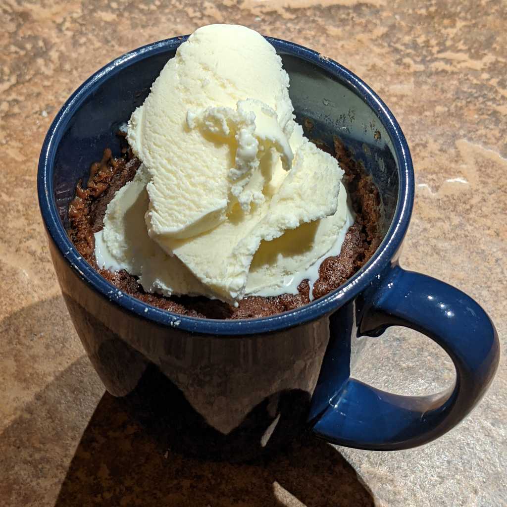 Chocolate mug cake topped with vanilla ice cream