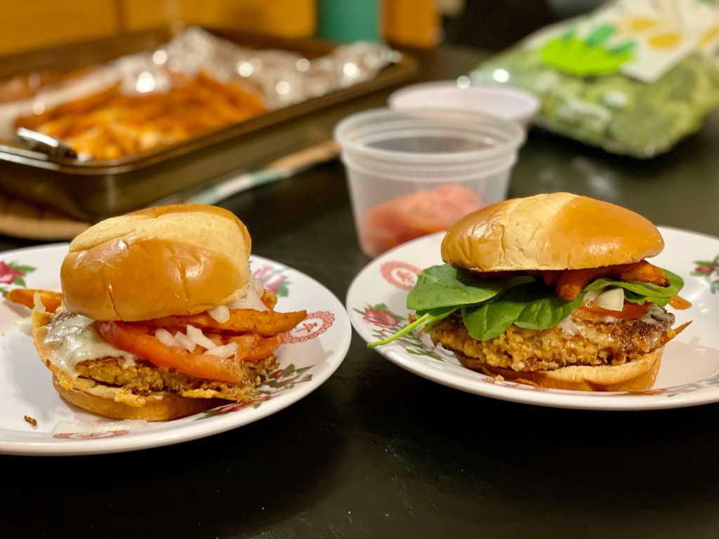 Closeup of two quinoa burgers with various toppings