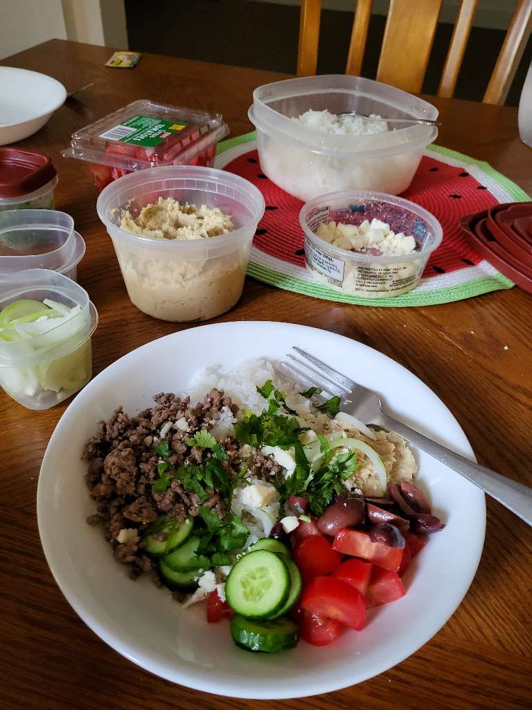 Hummus bowl with various ingredients in tupperware containers on the table