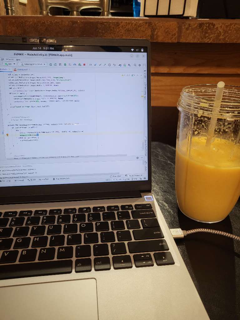 My computer with some mobile app code and a smoothie next to it