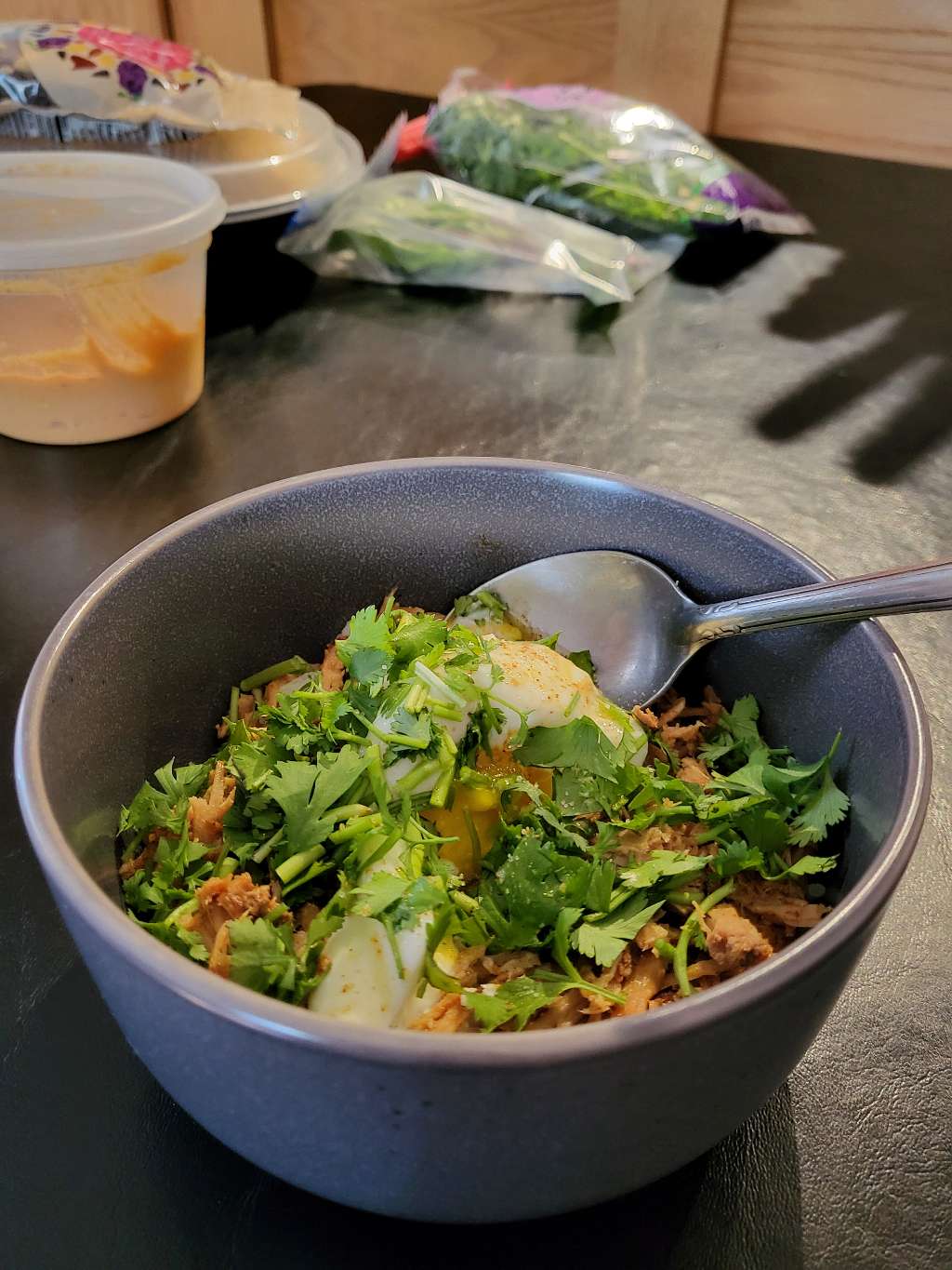 Pulled pork breakfast bowl with an egg and cilantro on top