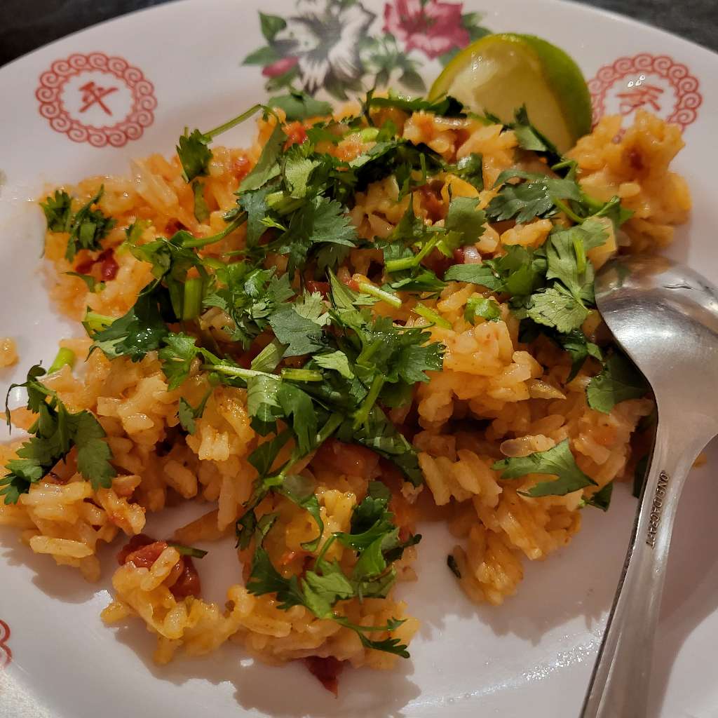 Tomato rice on a plate with a spoon