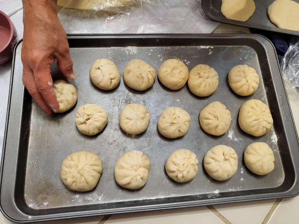 Uncooked bao arranged on a baking tray