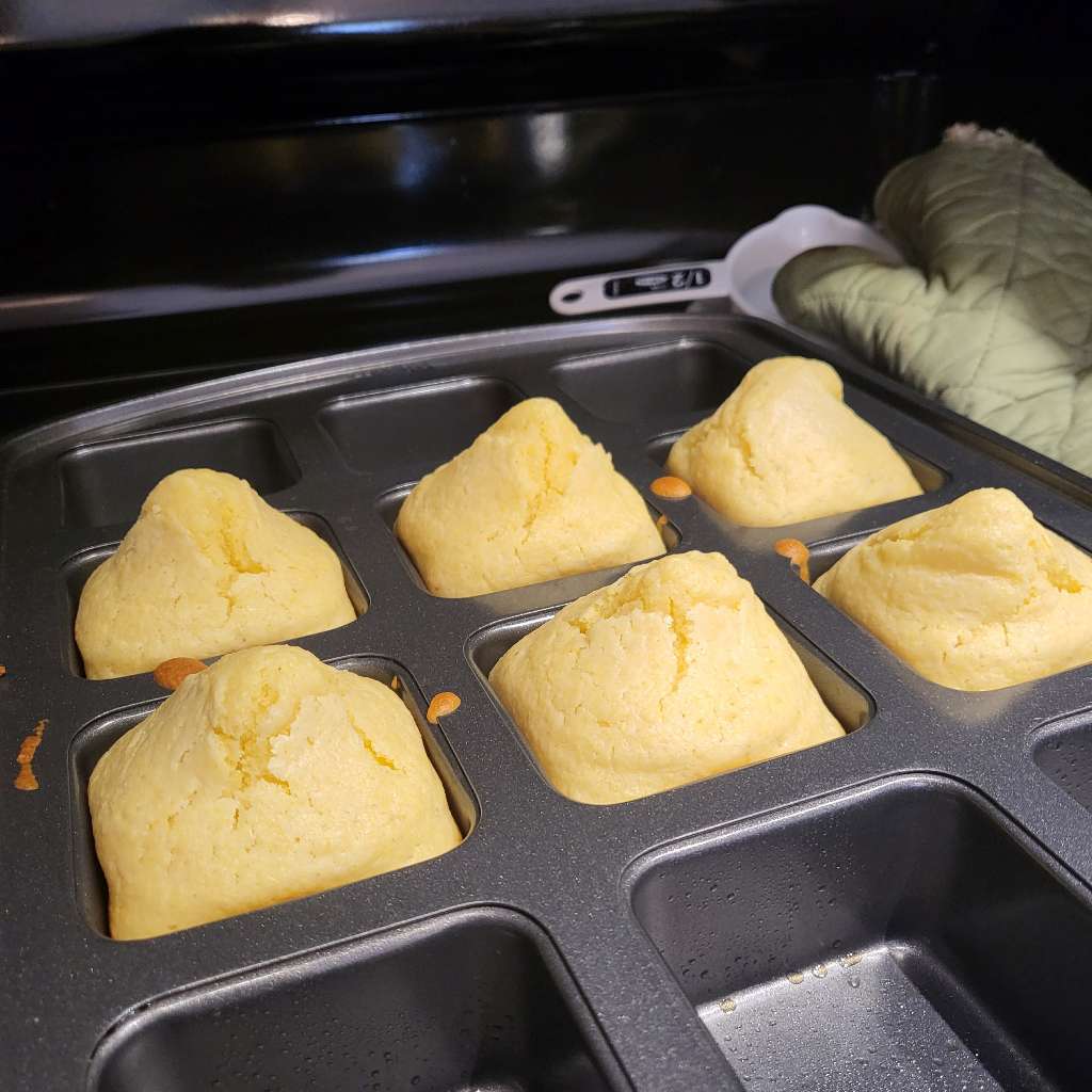 Freshly baked cornbread muffins in a square muffin tin