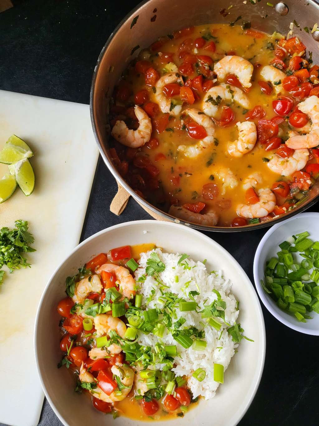 Garlic shrimp in coconut milk, served with rice and topped with lime, cilantro, and green onion for garnish