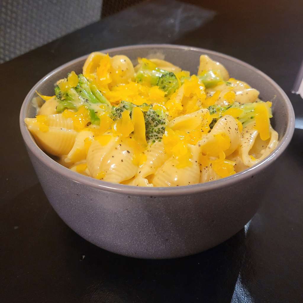 A bowl of the broccoli shells and cheese, taken from the side