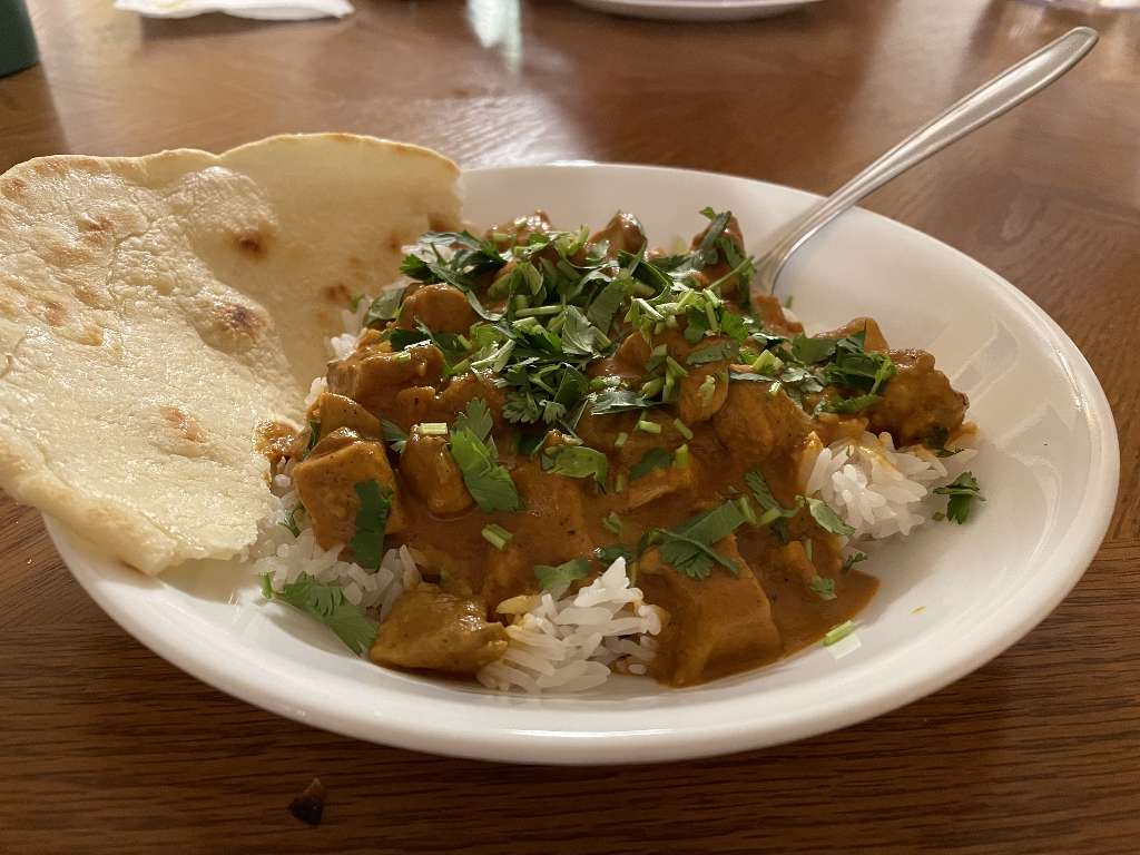 Tikka masala, rice, and naan in a bowl