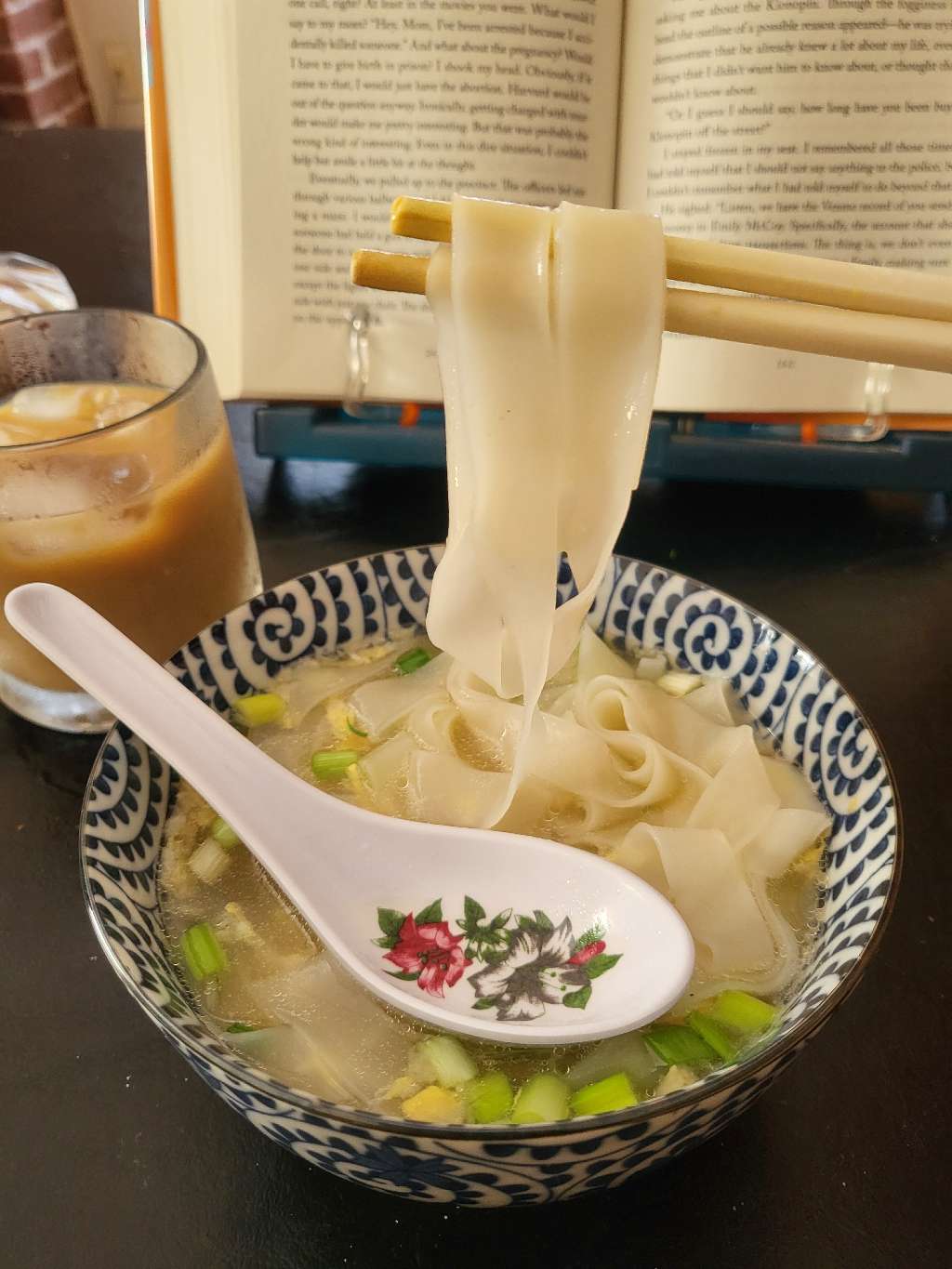 Holding some flat rice noodles with chopsticks
