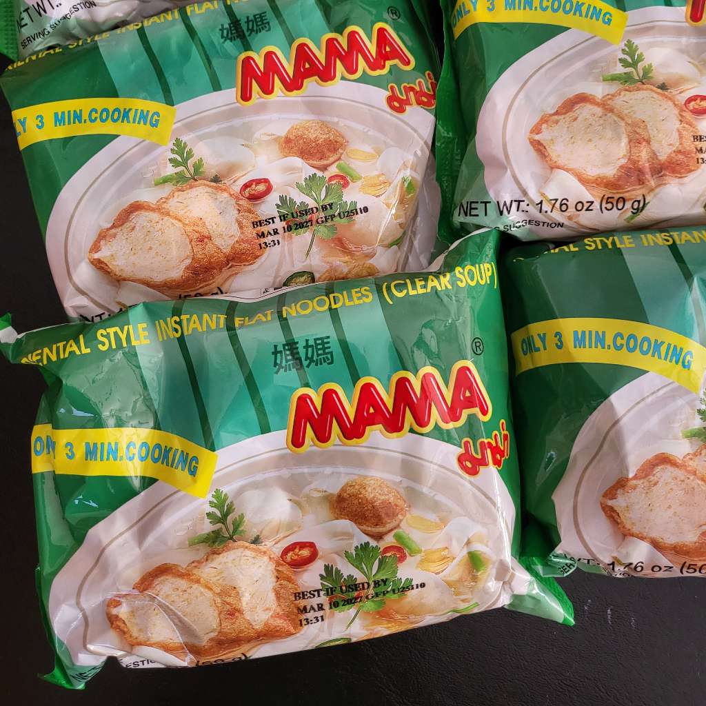 Several packs of Mama flat rice noodles in clear soup