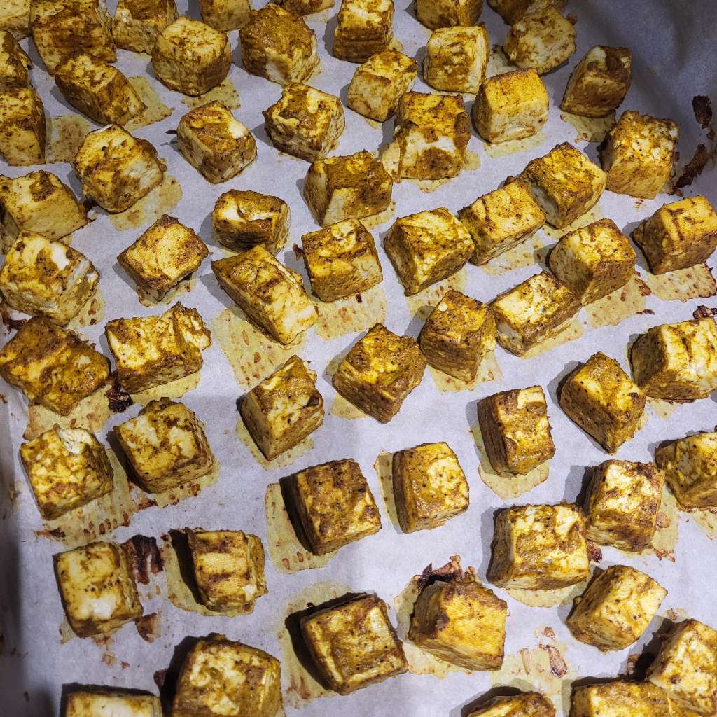 Cubed, sauced, and baked tofu, all sitting on a baking tray
