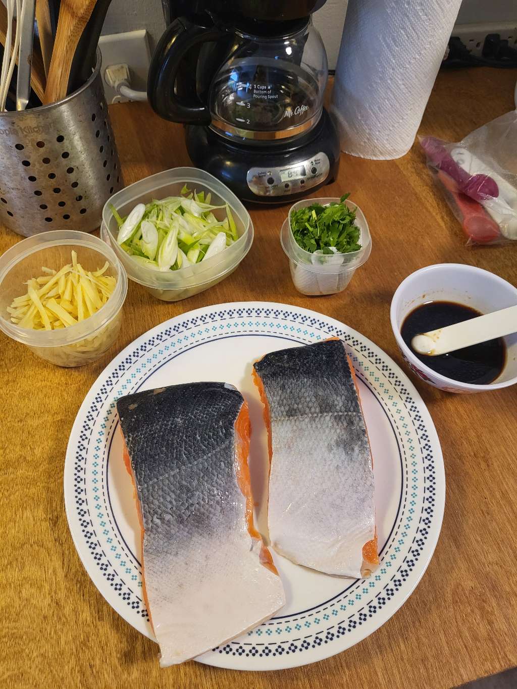 Ingredients for making scallion ginger salmon - Two pieces of salmon and some sliced ginger, scallions, and cilantro
