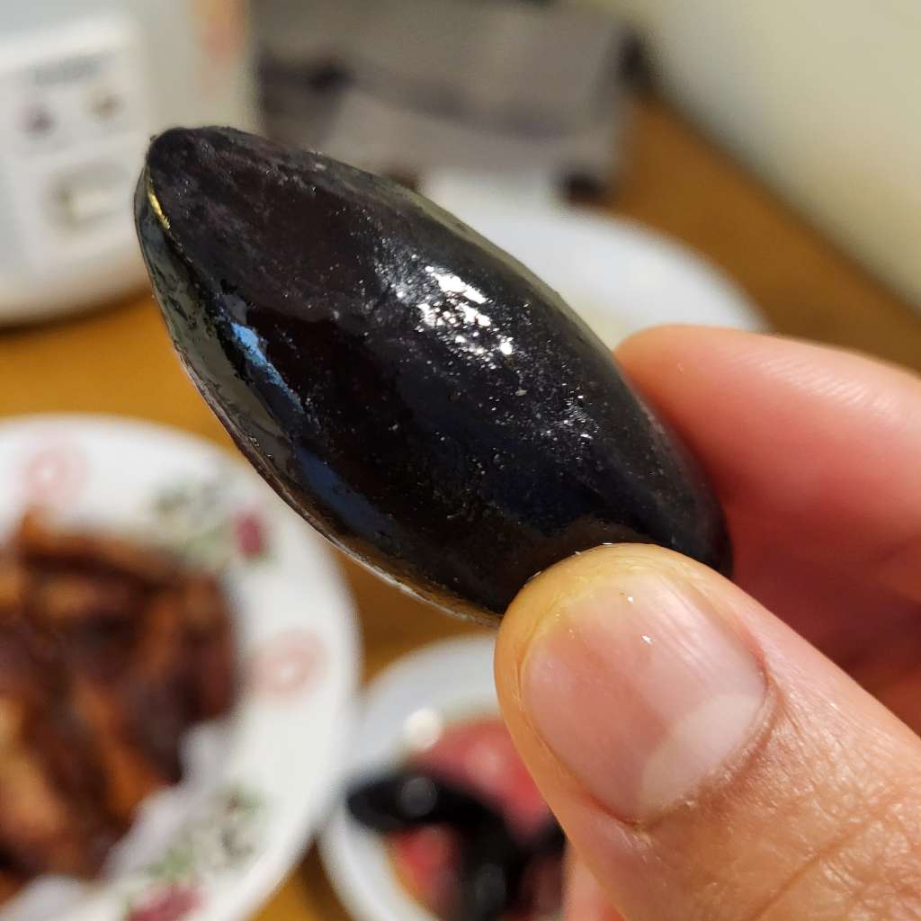Me holding up a single whole olive