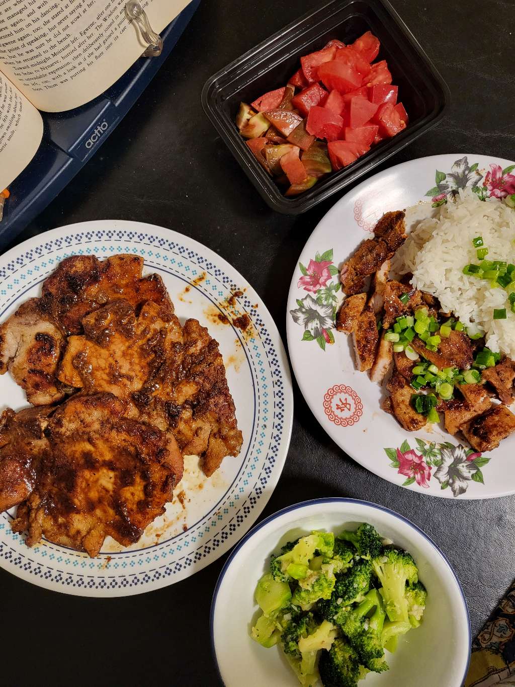 Some Vietnamese style pork chops, topped with scallions in oil, with broccoli and tomatoes on the site